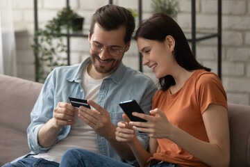 We can well afford to buy it. Happy loving married couple make payment purchase at ecommerce web...