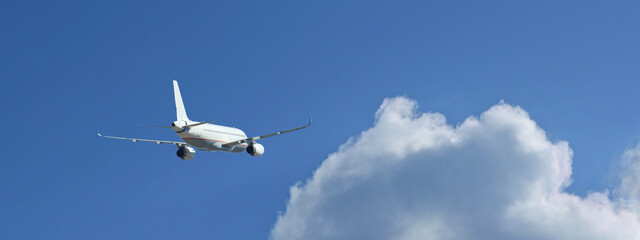 Zoom photo of passenger plane flying above deep blue cloudy sky