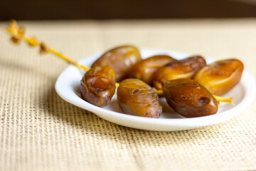 Deglet Nour (date-palm of light) dates on a white plate,  Ramadan concept, space for text 