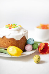 Easter composition with traditional Easter cake, painted quail eggs and tulips. Selective Focus