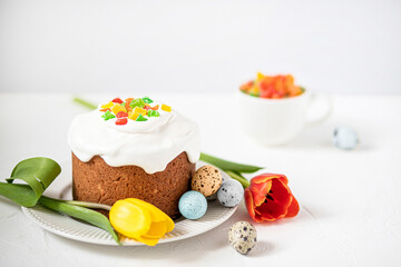 Easter composition with traditional Easter cake, painted quail eggs and tulips. Selective Focus
