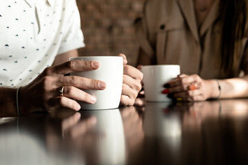 Man and woman drinking coffee. framing on hands. Close up woman and man holding cups of coffee on...
