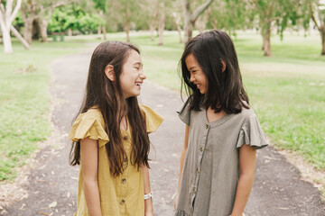 Fototapeta premium Happy and healthy mixed Asian young girls smiling in the park, best friends and friendship and diversity concept