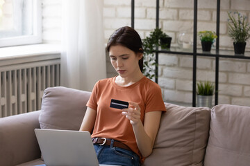 Fraud prevention. Focused female shopper study ebank website read information on pc screen before...
