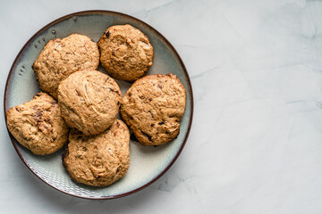 Top view of crunchy oatmeal chip cookies fresh baked biscuits with chocolate and cocoa in a plate on the table homemade food concept with copy space