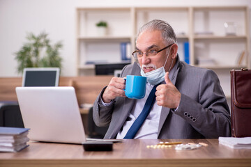 Coronavirus infected old businessman employee sitting in the off