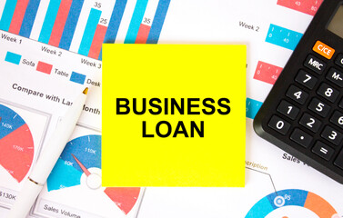 Yellow sticker with text Business Loan with calculator white pen on the diagrams