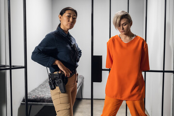 Shooting a movie about a women's prison. Backstage. Asian warden and a criminal girl in a yellow...