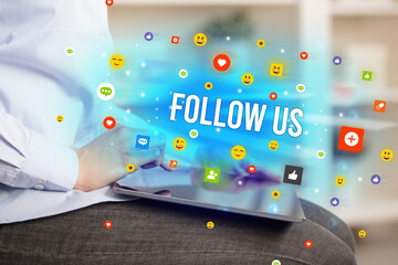 Close up of business person playing multimedia with social media icons and FOLLOW US inscription