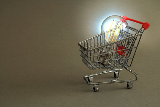 A Lightbulb In A Shopping Cart. Shop For A Cheaper Energy Supplier Concept.