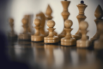 White's pieces on the chessboard. Wooden chess pieces on the chessboard.