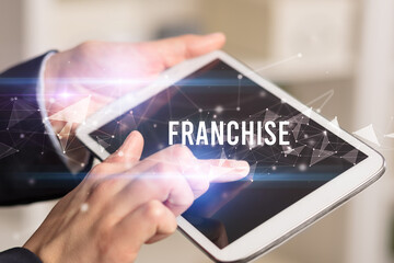 Close up hands using tablet with FRANCHISE inscription, modern business technology concept