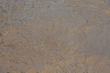 The texture of a glossy uneven surface with streaks. Wall surface. Abstract background. Close-up. Place for text