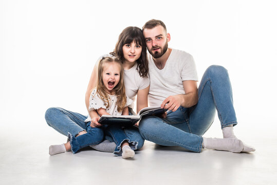 Happy family with daughter read children book laying on floor on white background