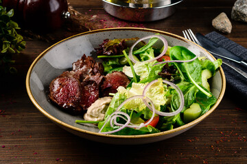 Grilled steak with green lettuce, cucumber and fresh rosemary. Home made tasty food. Concept for a tasty and healthy meal. fresh salad with grilled beef