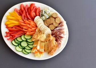 Healthy appetizer charcuterie platter with cheese, vegetables and crackers for party buffet food. Photo concept, background food, copy space