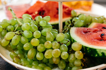 Plate with grapes and watermelon on the festive table horizontal close-up