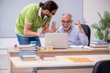 Old male teacher and young male student in the classroom