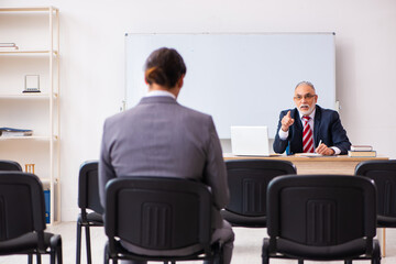 Two businessmen in the classroom in pandemic concept