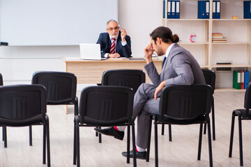 Two businessmen in the classroom in pandemic concept