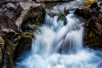 small waterfall of a fast and crystalline mountain river, on a bedrock, long exposure with silk effect, Catalan Pyrenees, Lleida, Spain