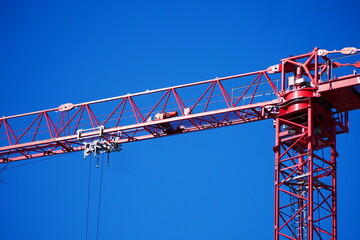 close up of a red construction crane with blue sky