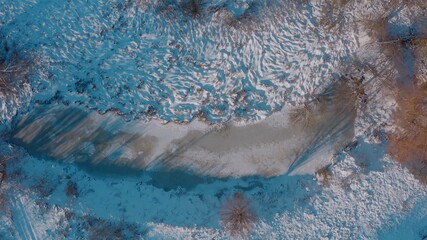 top view of a mysterious scary winter lake, a strange place with unusual energy in the green northern forests. Topshot - Aerial Flight 