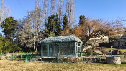 Traditional old greenhouse structure in the elegant large botanical garden on a large mansion estate near Esposende, Portugal. Cute small greenhouse in a private Garden and pond.