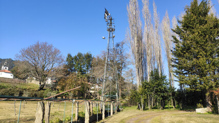 Obraz premium Traditional, old fashioned water pumping ranch windmill in a large mansion estate near Esposende, Portugal. Old Farm windmill for pumping water with spinning blades.