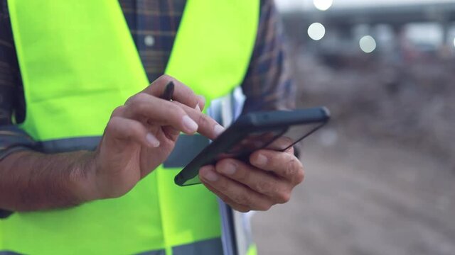 engineer working usung smartphone at the construction site