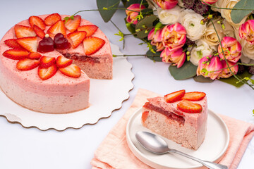 Delicious strawberry frozen gradient colour slice cake with strawberries. Strawberry cake with flowers on the table for Valentin's day or birthday party. Withe background. High quality photo
