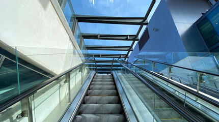 Obraz premium A modern outdoor escalator with a view upward looking to the sky