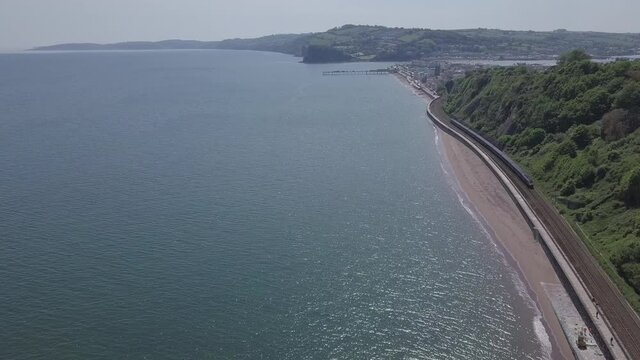 Teignmouth Rail Line Along Coast With Train Coming Towards The  Camera