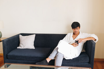 Young executive with checking cell in bathrobe