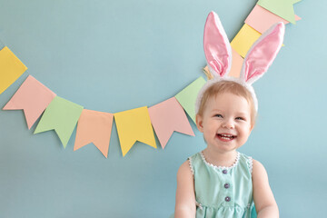 A cheerful girl with a smile in her rabbit ears. Easter holiday. A happy child.