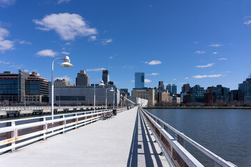 Pier 34 along Hudson River overlooking Tribeca buildings in Manhattan. New York City skyline view.