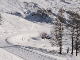 Obraz premium ski track in the mountains man walking into the wild snowy mountain way, silhouette marchant dans la neige et un paysage sauvage enneigé montagne 