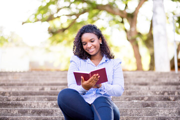 Girl sitting on staircase and reading a book.