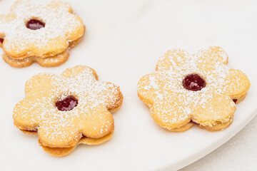 Jam-filled shortbread cookies in flower shape close up. Fresh baked delicious homemade dessert