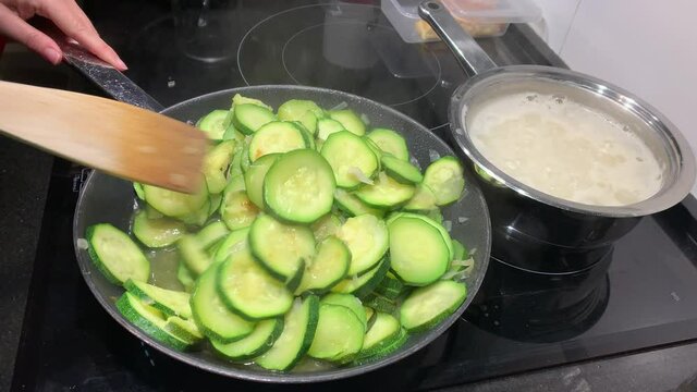 Courgettes being cooked in a frying pan