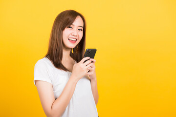 Asian happy portrait beautiful cute young woman teen smiling standing wear t-shirt using smart...