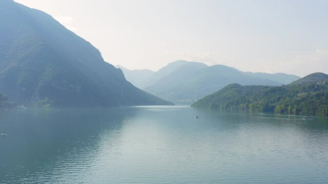 Misty morning on the Perucac lake surrounded by steep mountains 
