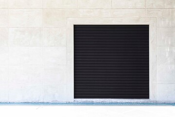 Closed Black metal shutter garage door at building