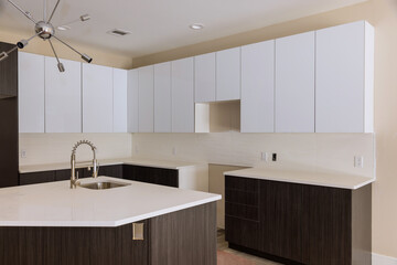 Installing new sink tap in modern kitchen cabinet.