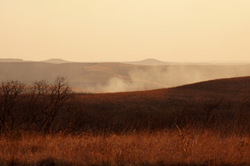 Fototapeta na wymiar smoke in the prairie hills during a wildfire burning