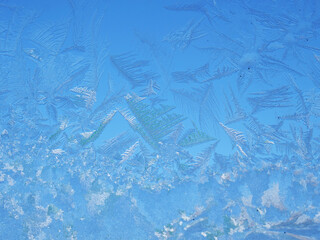 Abstract view of frost on the window surface. Blue crystal frosty texture. Cold winter background.