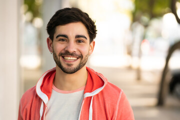 Close-up of young man smiling outdoors.