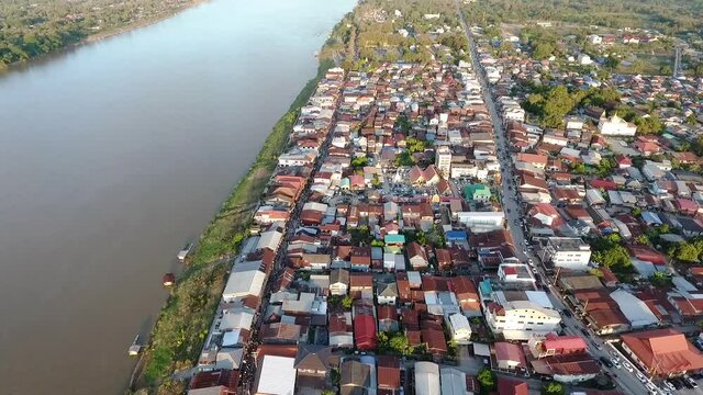  the aerial view of the Mekong river and the riverside village that has a local road passed the residential zone 
