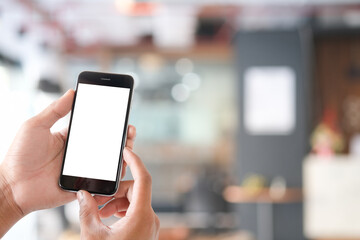 Mock up smartphone of hand holding black mobile phone with blank white screen.