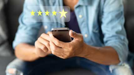 Customer pressing on smartphone with five star icon for feedback review satisfaction service